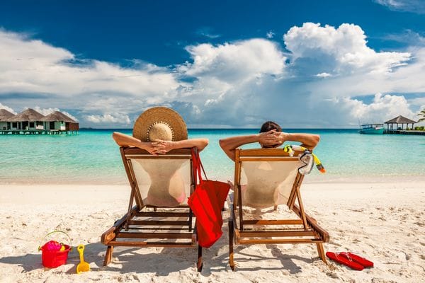 Couple,In,Loungers,On,A,Tropical,Beach,